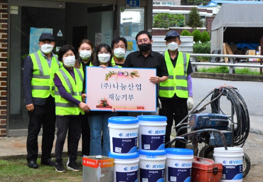 2021년 왼쪽 사회공헌활동 사진, 7명의 사람이 (주)나눔산업 재능기부 판넬을 들고 서서 사진을 찍고 있다.